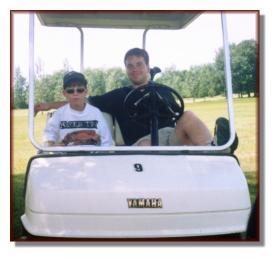 Andy and Mike driving a golf cart