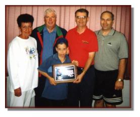 Rod, Paulette and Mike Moffitt presenting Mike's school St. John Bosco with a plaque